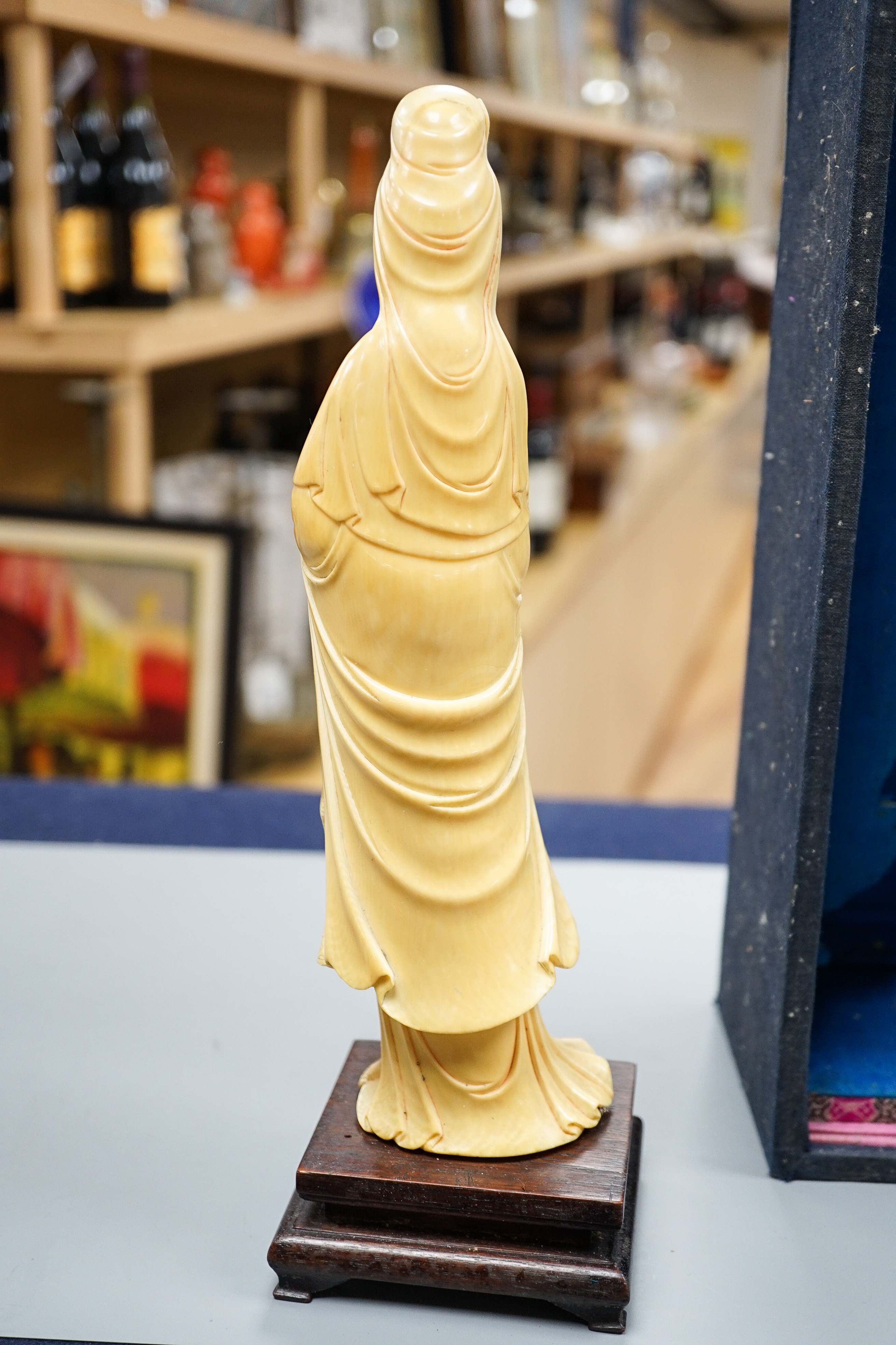 An early 20th century Chinese ivory figure of Guanyin holding a Buddhist rosary 25cm, wood stand and case